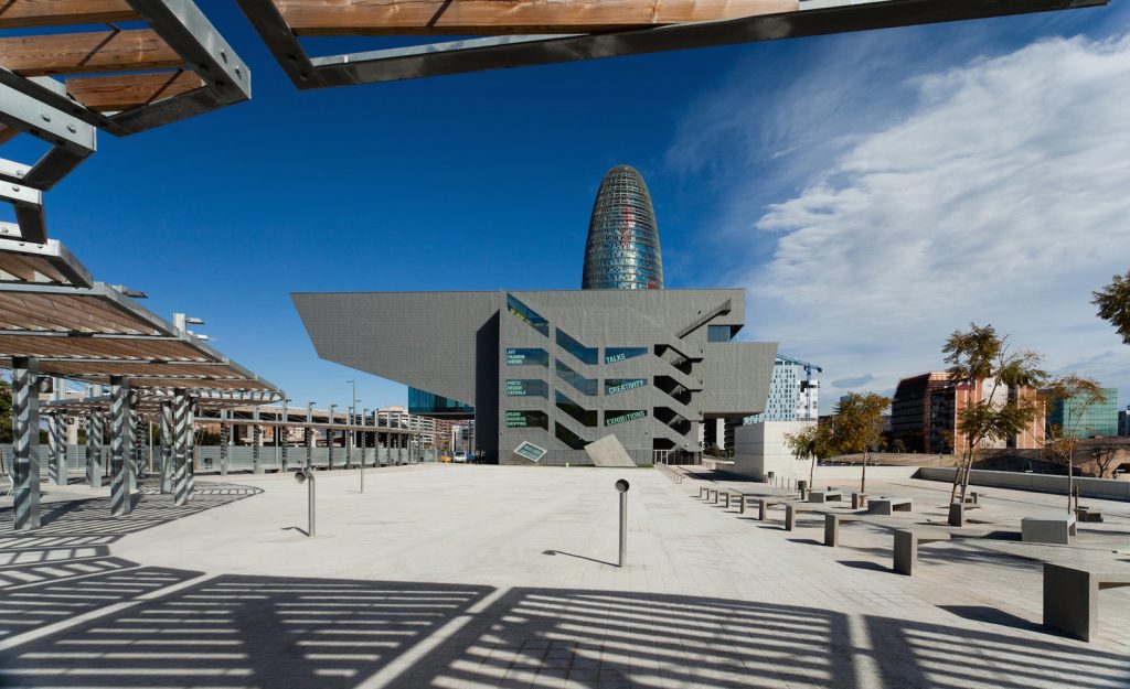 Design Hub Barcelona - MBM Architects - Modern architectural complex with geometric designs, an open space with square seating arrangements, and a cylindrical building