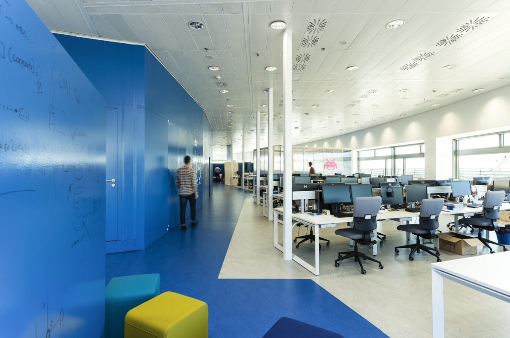 eDreams Offices - Guim Costa - Dynamic office space with a person in motion, showcasing vibrant blue design elements