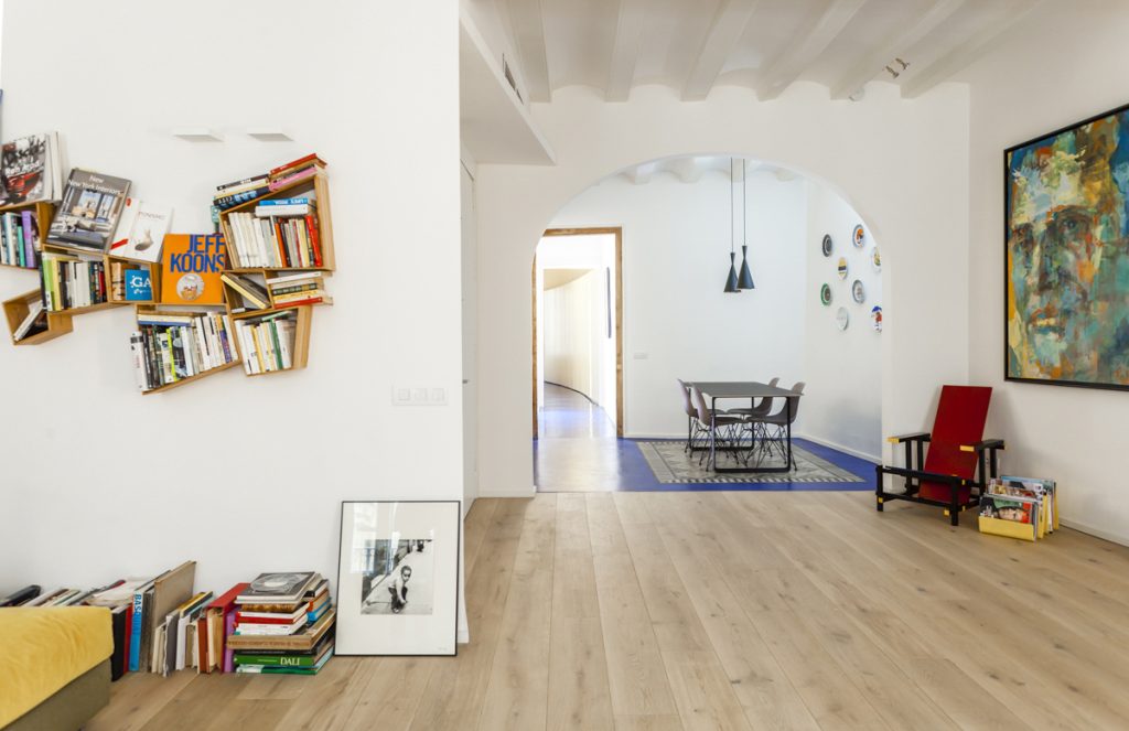 Libreteria Flat - AcabadoMate - Room with many books and artistic design opens to a modern dining room
