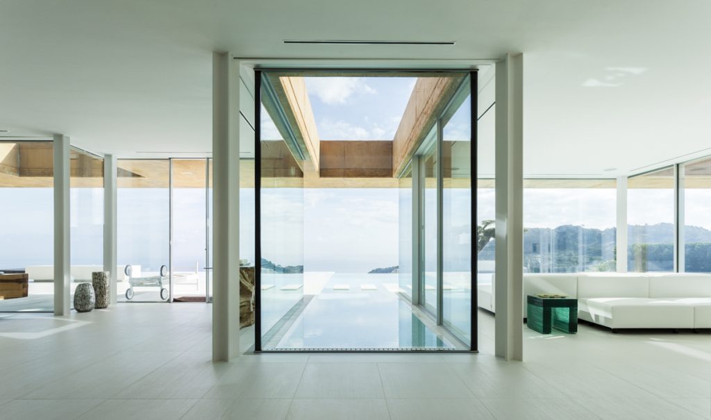 Aiguablava House - Mano Arquitectura - Bright and minimalist modern interior with views of a sunny natural landscape